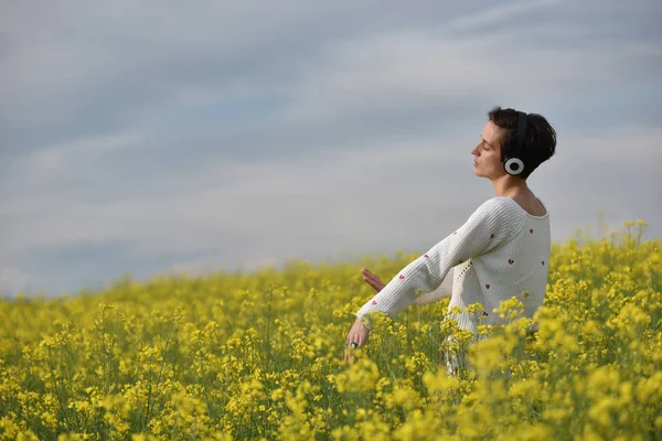 Кавказская девушка слушает музыку с наушниками на открытом воздухе — стоковое фото
