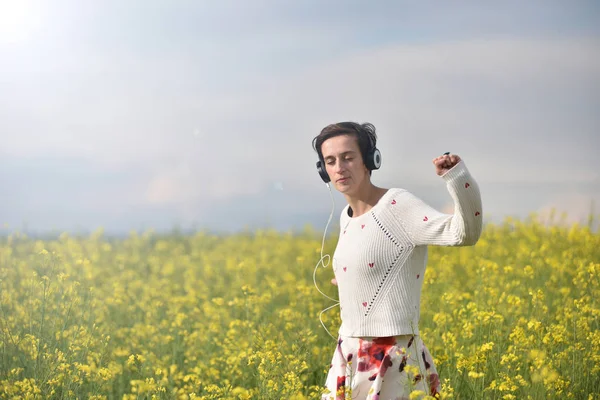 Hermosa chica caucásica escuchando música con auriculares en th — Foto de Stock