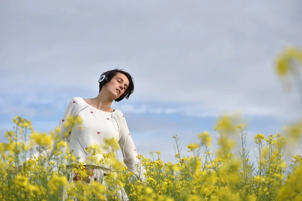 Hermosa chica caucásica escuchando música con auriculares en th —  Fotos de Stock