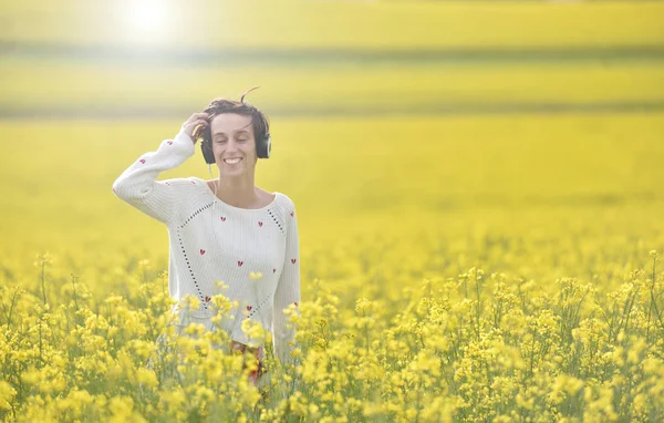 Beyaz kız açık havada kulaklık ile müzik dinlemek — Stok fotoğraf