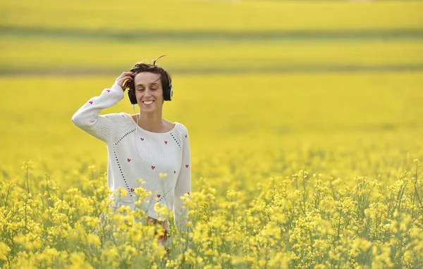 Beyaz kız açık havada kulaklık ile müzik dinlemek — Stok fotoğraf