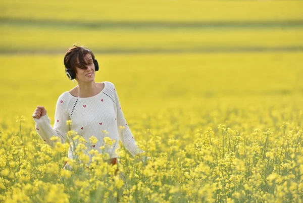 Beyaz kız açık havada kulaklık ile müzik dinlemek — Stok fotoğraf