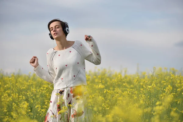 Hermosa chica caucásica escuchando música con auriculares en th —  Fotos de Stock