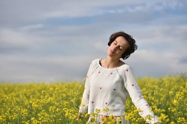 Bella ragazza caucasica ascoltare musica con cuffie in th — Foto Stock