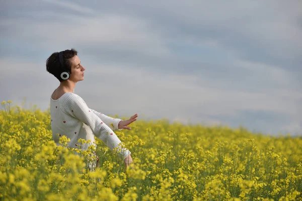 Hermosa chica caucásica escuchando música con auriculares en th — Foto de Stock