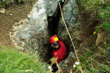 Caver descends in a cave clipart