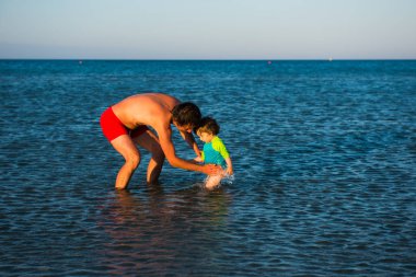 Baba ve kızı birlikte oynayan deniz suyu