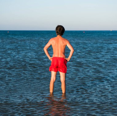 İnce adam deniz suyu kırmızı mayo poz