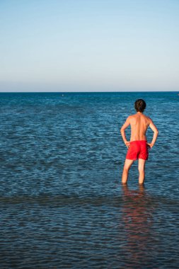 İnce adam deniz suyu kırmızı mayo poz