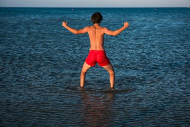 İnce adam deniz suyu kırmızı mayo poz