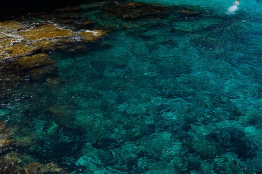 Kristal berrak turkuaz deniz suyu arka planı ve kayalık sahil