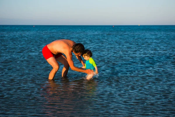 父と娘が一緒に海の水で遊ぶ — ストック写真