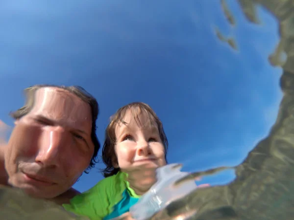 Podwodne widoki ojca i córki z zniekształconą twarz — Zdjęcie stockowe