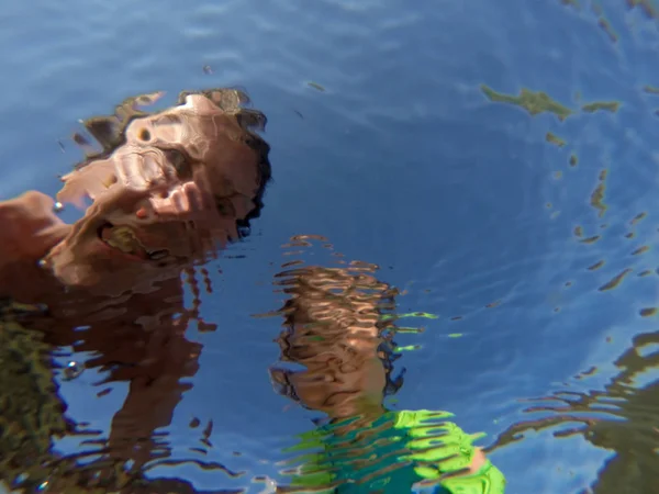 Unterwasseraufnahme eines Vaters und seiner Tochter mit verzerrtem Gesicht — Stockfoto