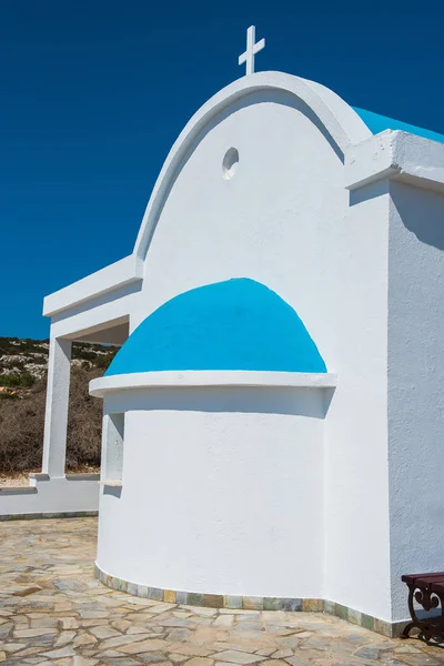 Capela branca tradicional com um telhado azul à beira-mar. Agioi... — Fotografia de Stock