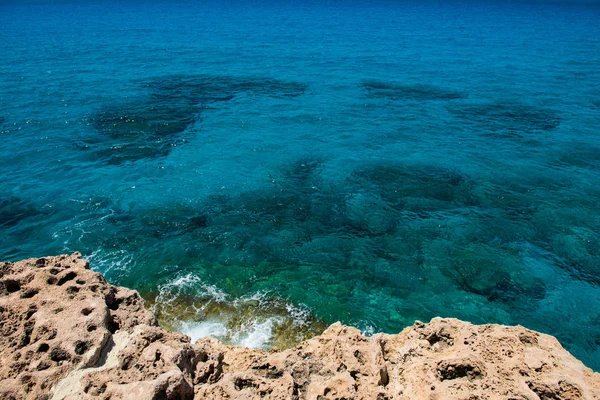 Kristalhelder turquoise zee water achtergrond en rotsachtige kust — Stockfoto