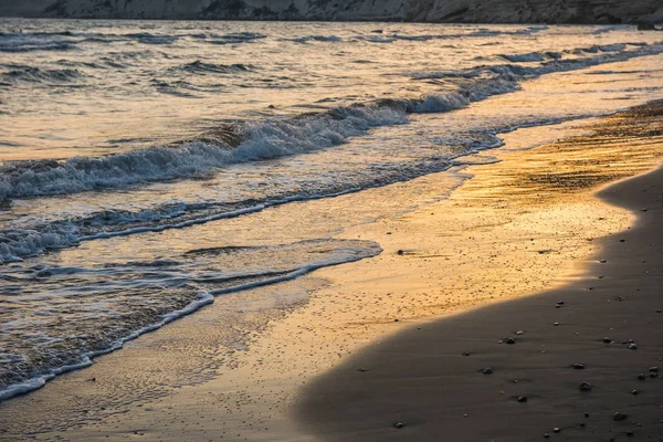 Ondas acercándose a la playa de arena durante el atardecer —  Fotos de Stock
