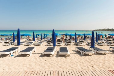 Turist beach umbrel altında bir kumlu plajda şezlong üzerinde rahatlatıcı