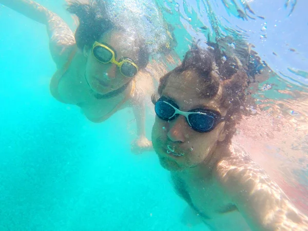 Pareja divirtiéndose bajo el agua en el mar — Foto de Stock