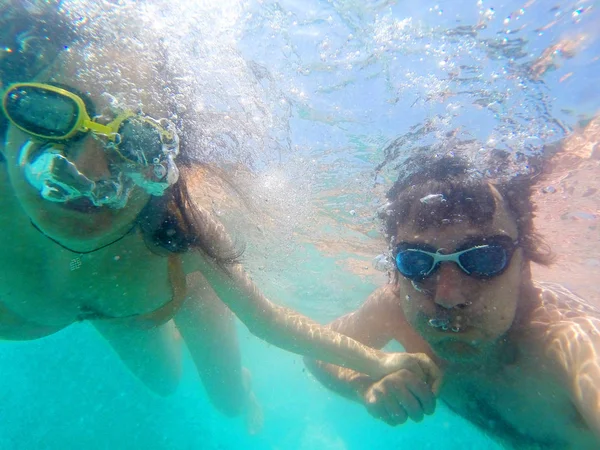 Pareja divirtiéndose bajo el agua en el mar — Foto de Stock