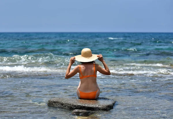 Сексуальна бікіні засмагає жінка розслабляється на пляжі з капелюхом — стокове фото