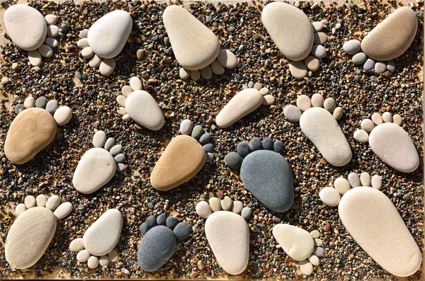 Sassi di ghiaia disposti come impronte sulla spiaggia — Foto Stock