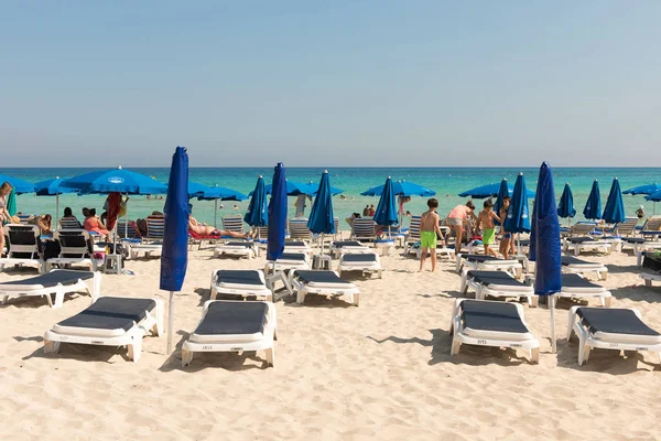 Turist beach umbrel altında bir kumlu plajda şezlong üzerinde rahatlatıcı