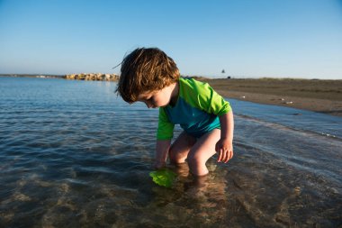Sığ deniz suda oynarken toddler bebek