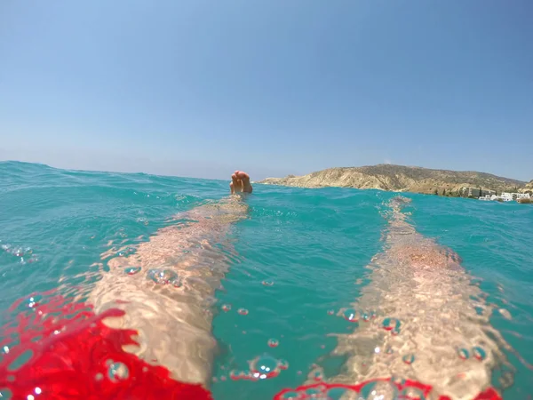Piernas de un nadador en traje de baño rojo flotando en el mar — Foto de Stock