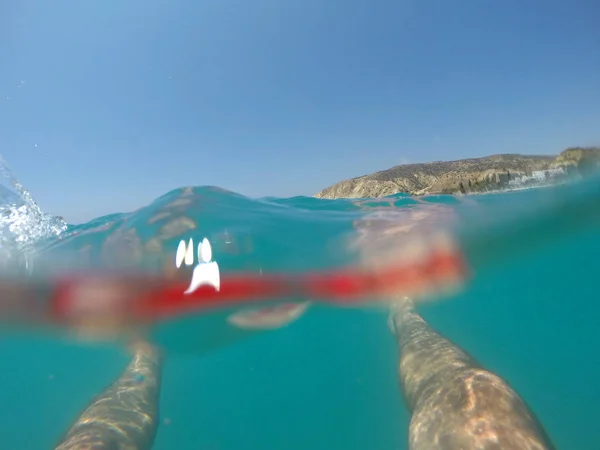 Πόδια του κολυμβητή σε κόκκινο μαγιό που επιπλέουν στη θάλασσα — Φωτογραφία Αρχείου
