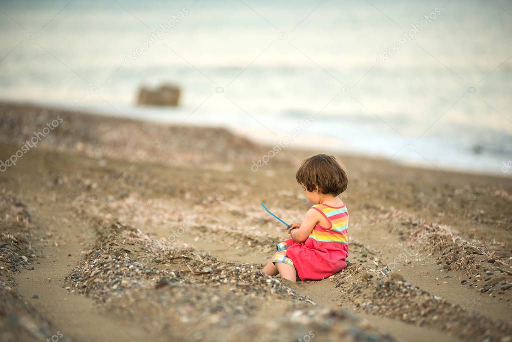 Toddler baby playing on a beach 