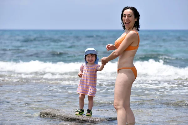 Mother having fun with her toddler baby in sea water — Stock Photo, Image