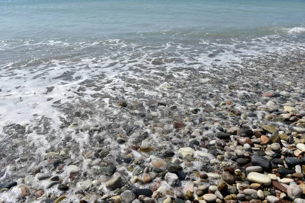 Olas marinas acercándose piedras de guijarro — Foto de Stock