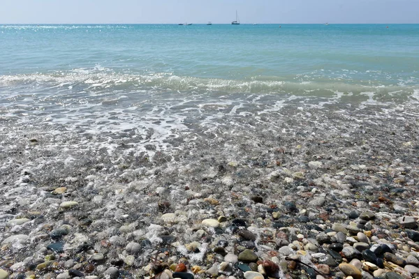 Zee golven naderende pebble stenen — Stockfoto