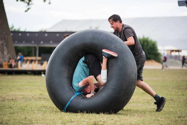 Young adults playing with an inner tube of a tractor — Stock Photo, Image