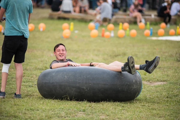 Young adults playing with an inner tube of a tractor — Stock Photo, Image