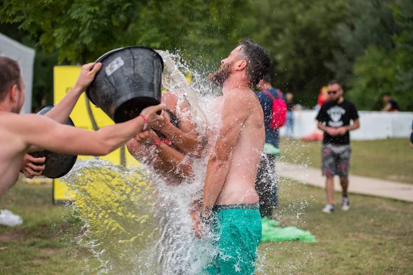 Guy spours vatten från en hink på huvudet vän — Stockfoto