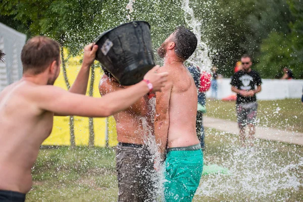 Guy spours vatten från en hink på huvudet vän — Stockfoto