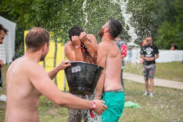 Guy spours vatten från en hink på huvudet vän — Stockfoto