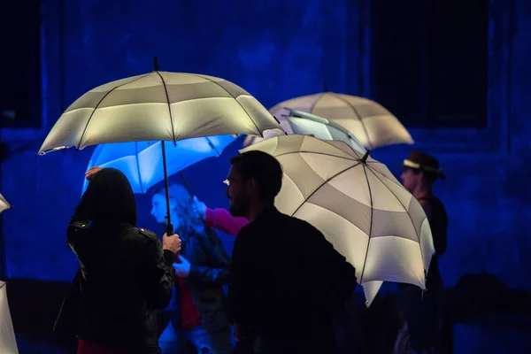 Parapluies colorés éclairés par des lampes à led dans la nuit — Photo