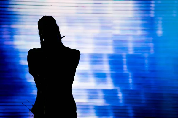 Silueta de un artista cantando en directo en el escenario — Foto de Stock