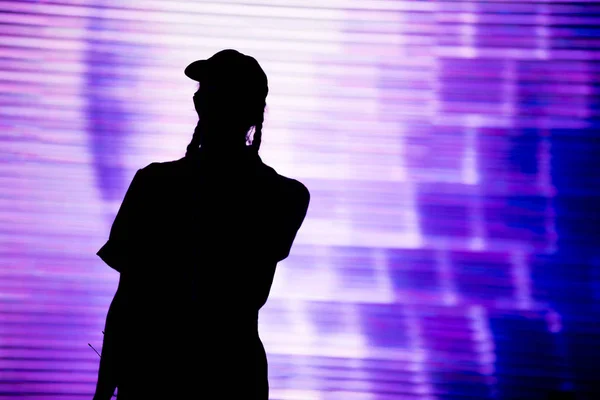 Silueta de un artista cantando en directo en el escenario — Foto de Stock