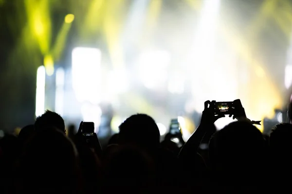 Braccia sollevate con smartphone per registrare un concerto dal vivo — Foto Stock