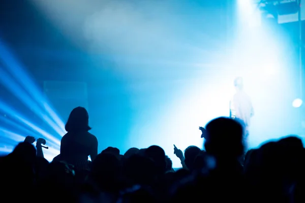 Silueta de la multitud de conciertos frente a las luces del escenario brillantes — Foto de Stock