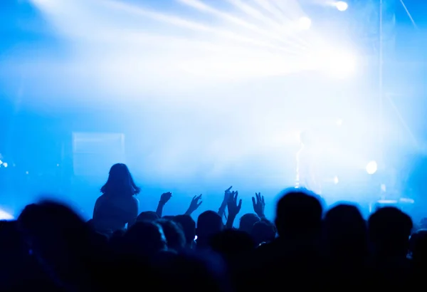 Silueta de la multitud de conciertos frente a las luces del escenario brillantes — Foto de Stock