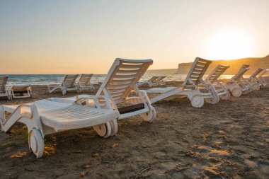 Gün batımında kumsal beyaz şezlong