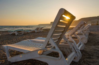 Gün batımında kumsal beyaz şezlong