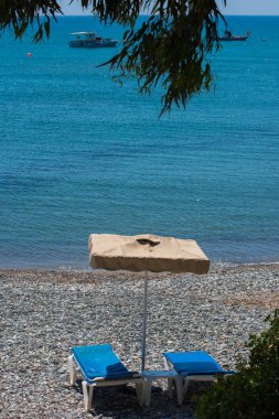 kumsalda güneşlik ve şemsiyeler