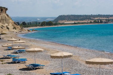 kumsalda güneşlik ve şemsiyeler