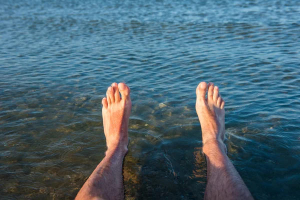 Deniz çamaşır adamın ayakları dalgalar